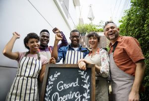 Diverse People with Grand Opening Sign First Day of Business