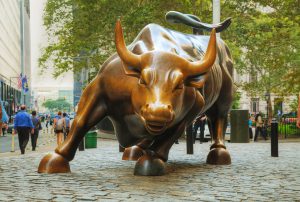 NEW YORK CITY - September 3: Charging Bull sculpture with people on September 3, 2015 in New York City. The sculpture is both a popular tourist destination, as well as "one of the most iconic images of New York".